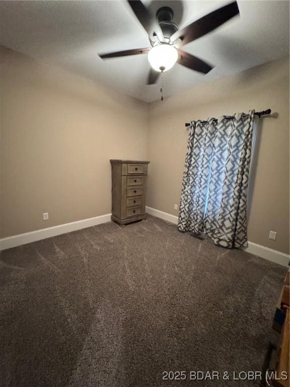 carpeted spare room with baseboards and a ceiling fan