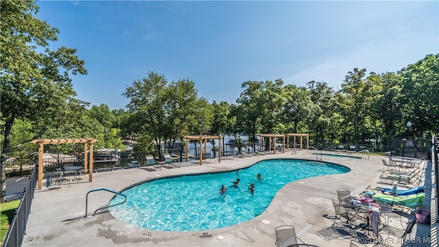 community pool featuring a patio area, a pergola, and fence