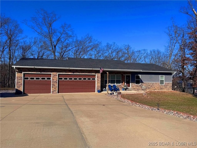 single story home with stone siding, an attached garage, driveway, and a front yard