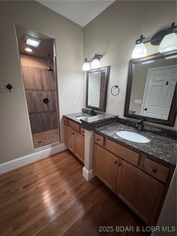 217 Highline Rd, Lake Ozark, MO 65049 - bathroom featuring tiled shower, wood finished floors, and two vanities