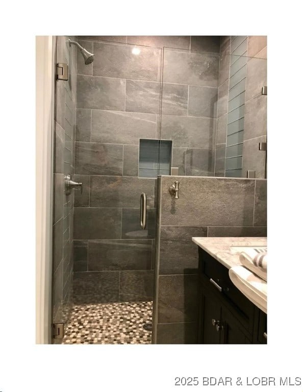 full bathroom featuring a shower stall and vanity