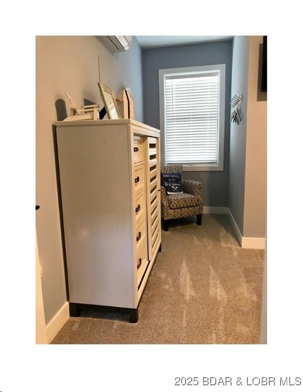 living area featuring an AC wall unit, carpet flooring, and baseboards