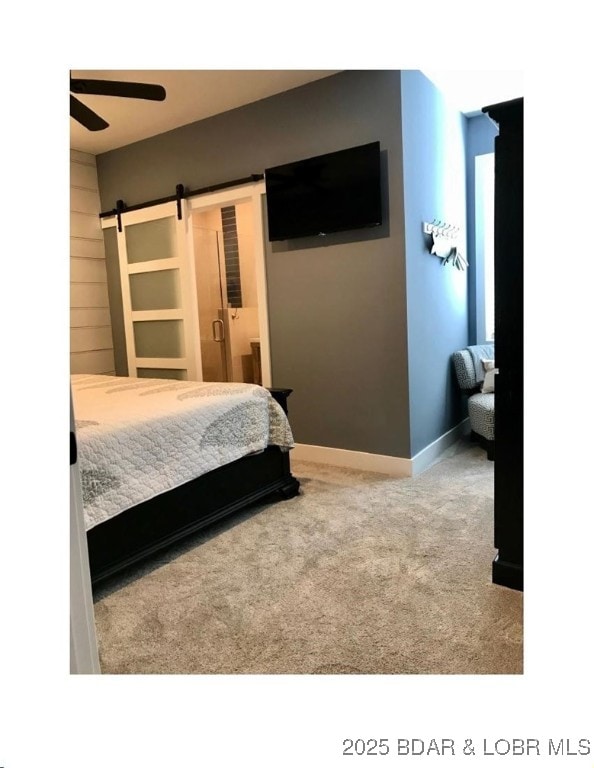 bedroom featuring carpet flooring, connected bathroom, baseboards, and a barn door