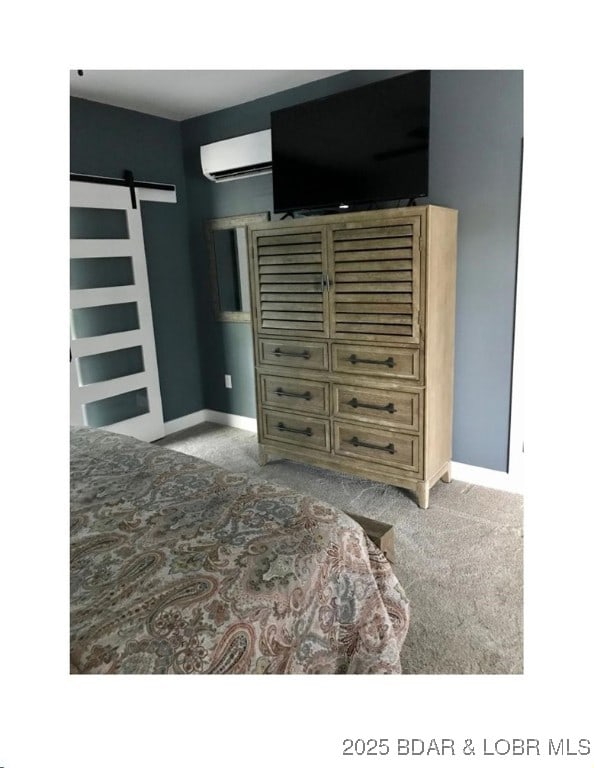 bedroom with baseboards, an AC wall unit, carpet, and a barn door