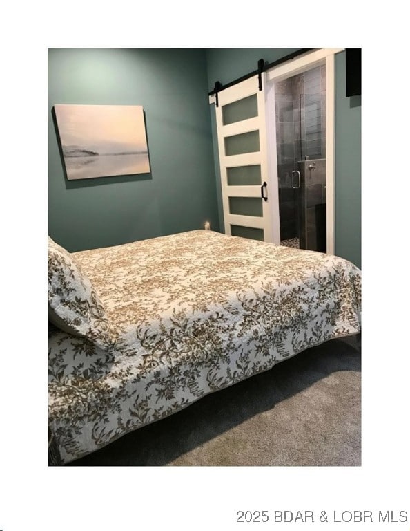 bedroom featuring a barn door and carpet floors