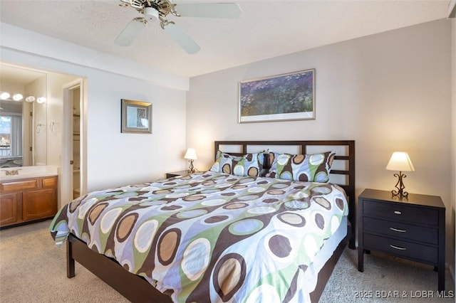 bedroom featuring a ceiling fan, ensuite bathroom, and light carpet