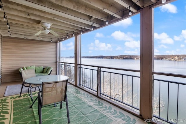 balcony with a ceiling fan and a water view