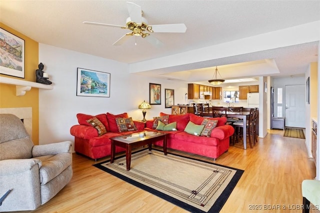 living room featuring light wood finished floors and a ceiling fan