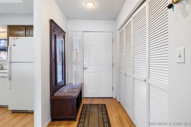 interior space with a textured ceiling and light wood finished floors