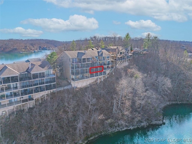 bird's eye view featuring a wooded view and a water view