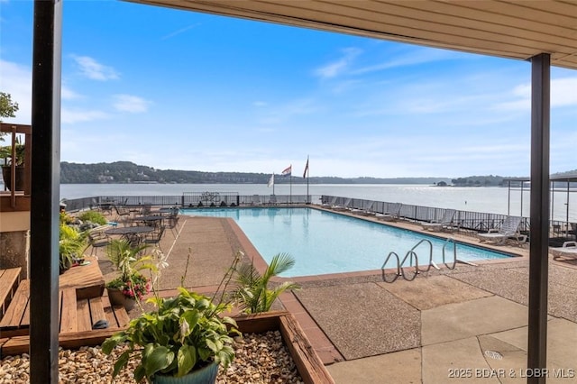 community pool with a patio and a water view