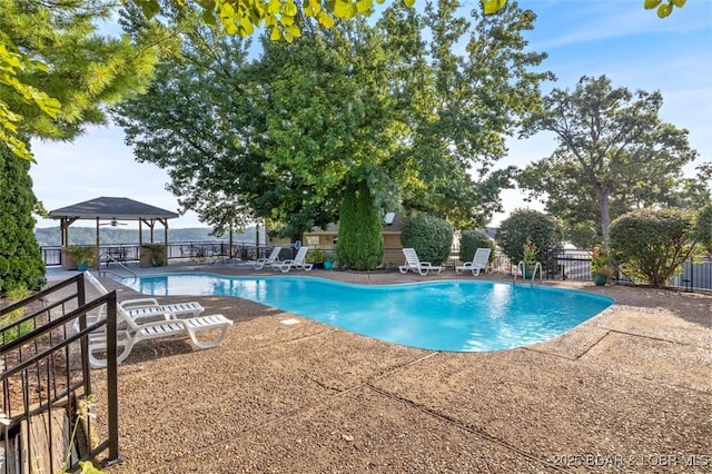 pool with a gazebo, a patio, and fence