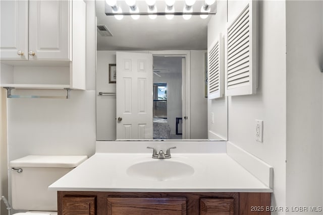 bathroom with visible vents, toilet, and vanity