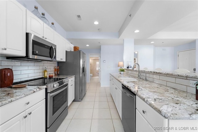 kitchen featuring a sink, tasteful backsplash, recessed lighting, stainless steel appliances, and light tile patterned flooring