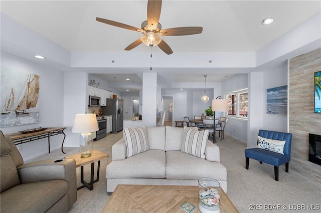 living room with recessed lighting, a ceiling fan, light colored carpet, and baseboards