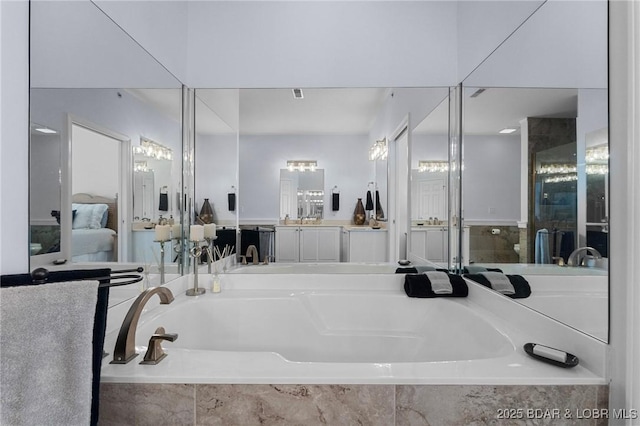 full bathroom with visible vents, vanity, a bath, and ensuite bathroom