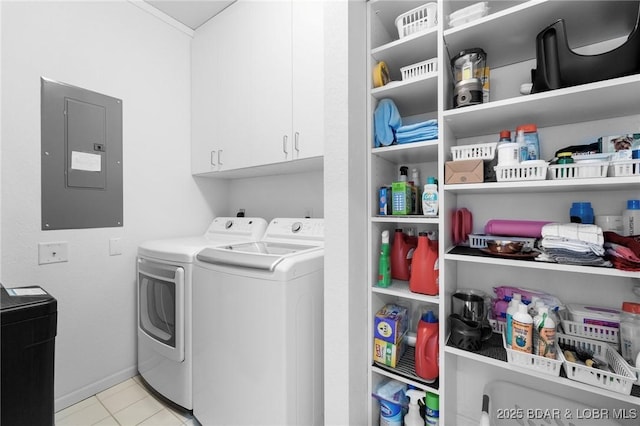 washroom featuring light tile patterned floors, baseboards, washing machine and clothes dryer, electric panel, and cabinet space