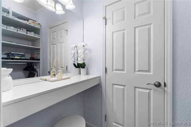 bathroom featuring a chandelier and crown molding