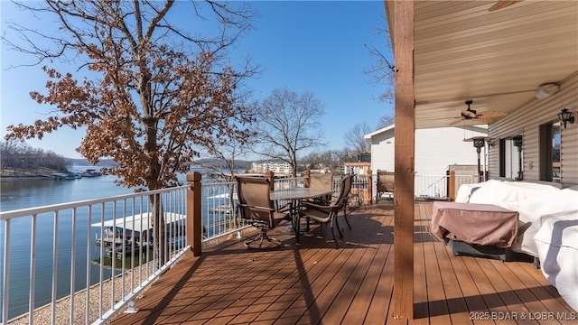 wooden terrace with a water view and ceiling fan