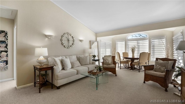 carpeted living area featuring baseboards and high vaulted ceiling