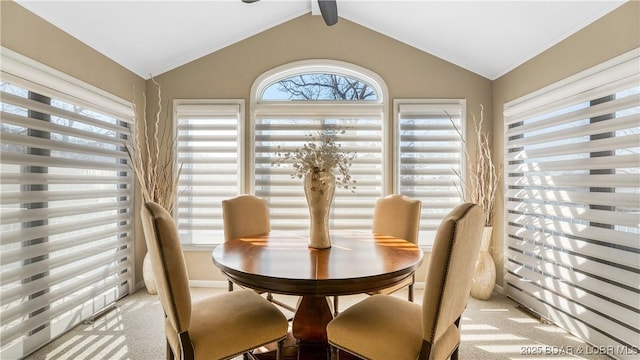 dining space featuring light colored carpet and vaulted ceiling