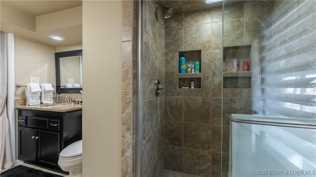 bathroom with vanity, toilet, and a stall shower