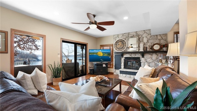 living room with a fireplace, wood finished floors, and a ceiling fan