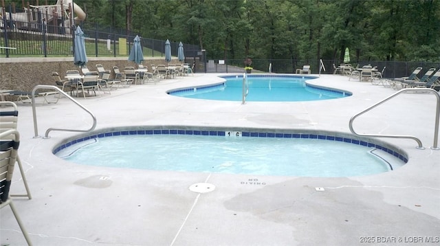 view of swimming pool featuring a patio and fence