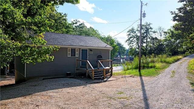 ranch-style house with a deck and a shingled roof