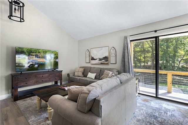 living room with baseboards, wood finished floors, and vaulted ceiling