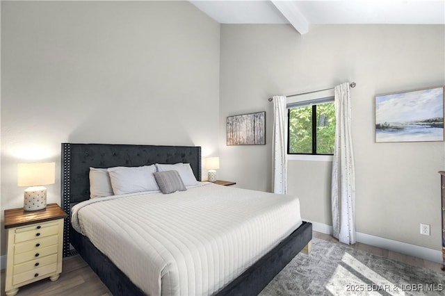 bedroom featuring baseboards, wood finished floors, and vaulted ceiling with beams