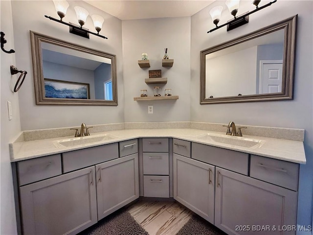 full bath with a sink, marble finish floor, and double vanity