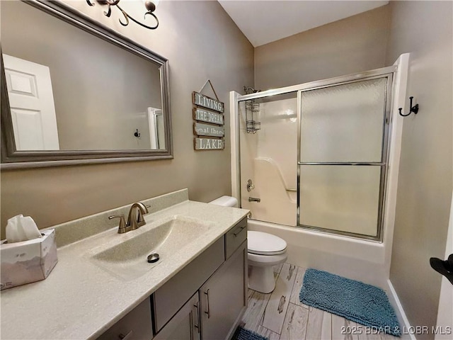 full bath featuring wood finished floors, toilet, vanity, and shower / bath combination with glass door