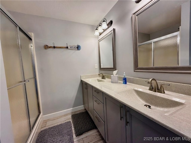 full bathroom featuring double vanity, a stall shower, and a sink