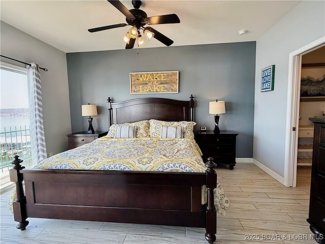 bedroom with baseboards, light wood-type flooring, and ceiling fan