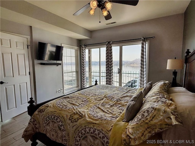 bedroom featuring visible vents, wood finished floors, access to exterior, and a ceiling fan