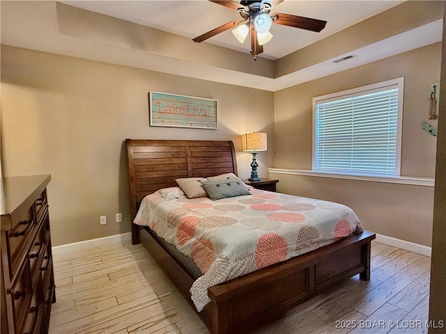 bedroom with light wood-type flooring, visible vents, and baseboards