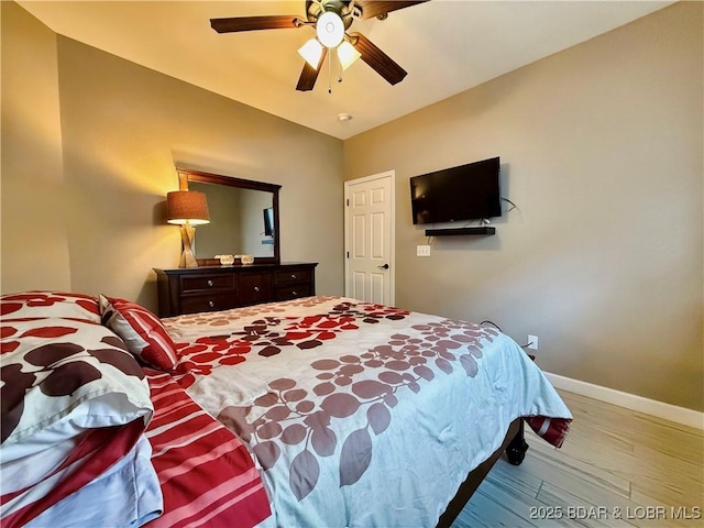 bedroom with ceiling fan, baseboards, and wood finished floors