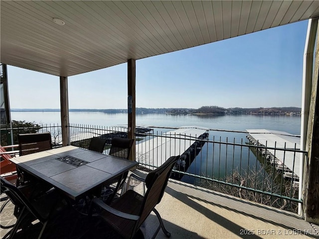 view of patio featuring outdoor dining area, a dock, and a water view