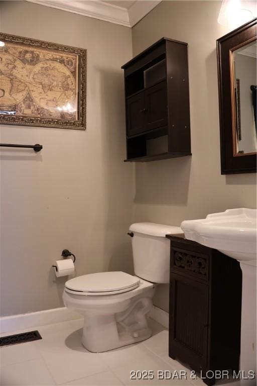 half bathroom featuring visible vents, baseboards, toilet, and ornamental molding