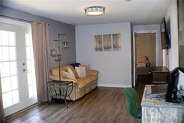 living area featuring french doors, baseboards, dark wood-type flooring, and a healthy amount of sunlight