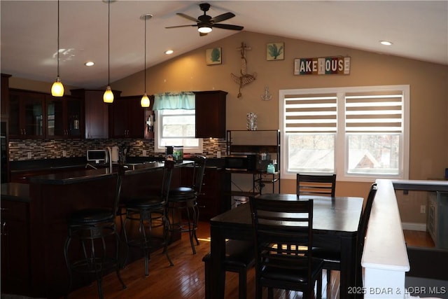 dining room featuring recessed lighting, lofted ceiling, dark wood-type flooring, and a ceiling fan