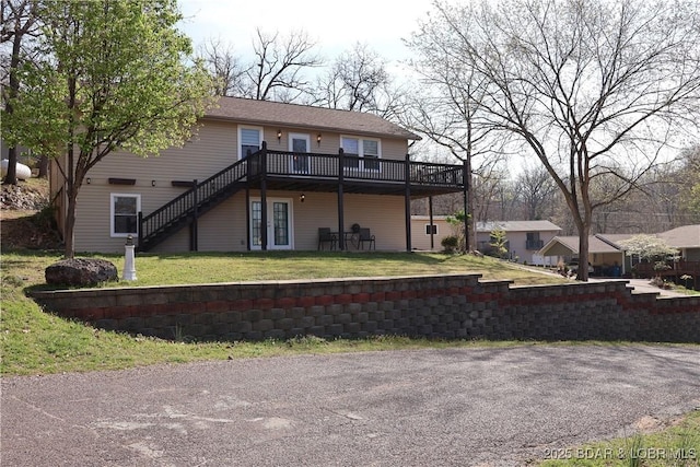 back of house with stairway, a deck, and a lawn