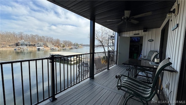 wooden terrace featuring ceiling fan and a water view