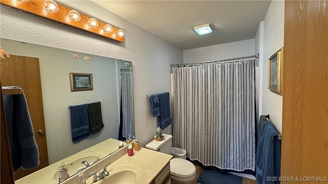 bathroom featuring a shower with shower curtain, toilet, a textured ceiling, and vanity