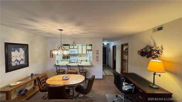 dining room featuring visible vents and dark carpet