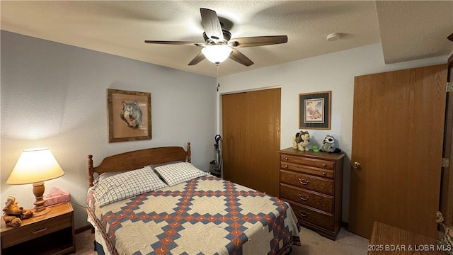 bedroom featuring light carpet, a closet, a textured ceiling, and ceiling fan