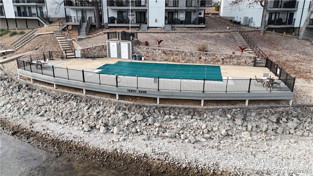 pool featuring stairs, a patio, and fence