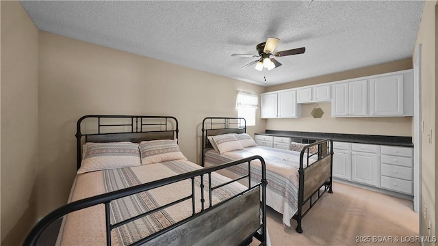 bedroom featuring light colored carpet, a textured ceiling, and a ceiling fan