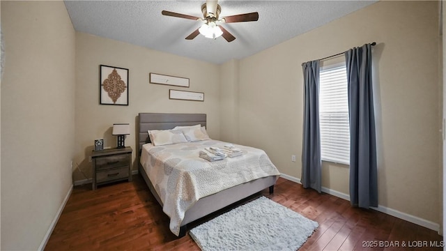 bedroom with ceiling fan, baseboards, a textured ceiling, and wood finished floors